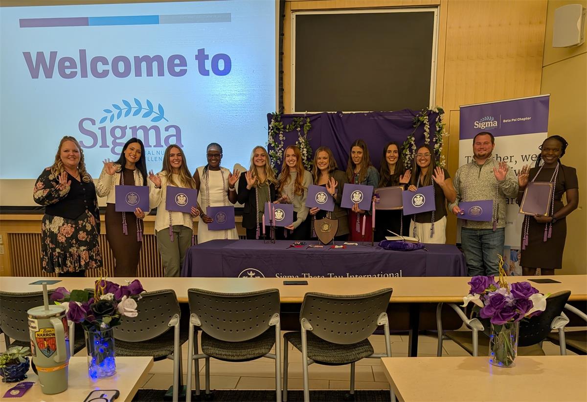 Counselor and students standing for photo after their induction ceremony. 